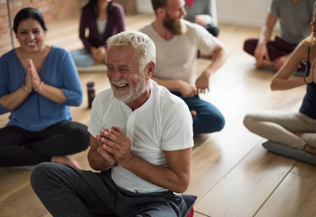 Happy senior man in a yoga class